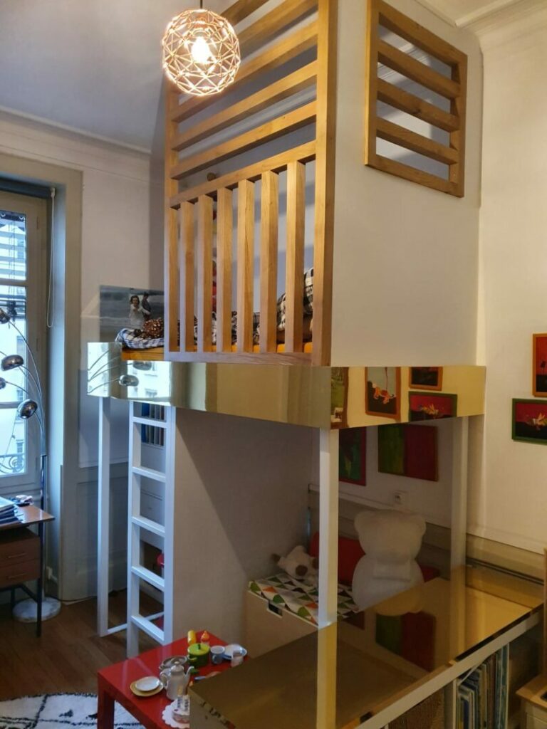 L'image montre une jolie chambre d'enfant avec des éléments en bois